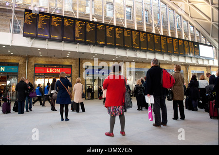 Contrôle des passagers horaires de train à la gare de Kings Cross Station, terminus de la ligne côtière est, Londres, Angleterre. Banque D'Images