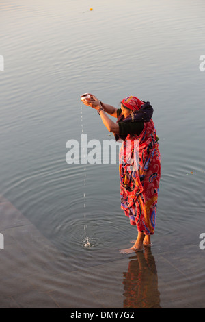 Pilgrim adorant le soleil à la rivière Narmada Maheshwar Madhya Pradesh Inde Banque D'Images