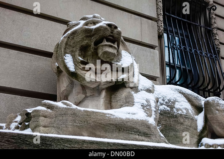 Lion en pierre dans la neige à l'ancien QG de la police dans la Petite Italie de New York City l'hiver Banque D'Images