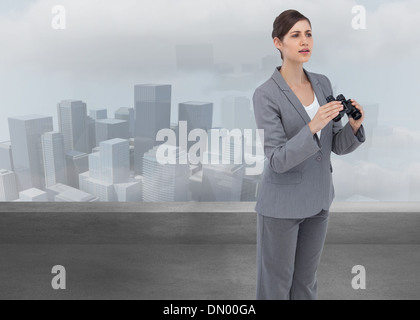 Composite image of businesswoman with binoculars Banque D'Images