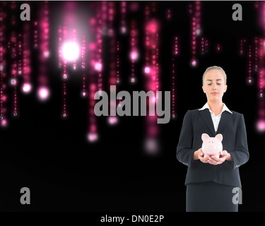 Composite image of businesswoman holding pink piggy bank Banque D'Images