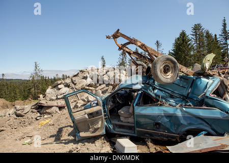 Brisé après un accident de voiture dans un dépotoir avec d'autres déchets sur une journée ensoleillée. Banque D'Images