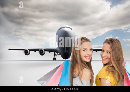 Image composite de deux jeunes femmes with shopping bags Banque D'Images