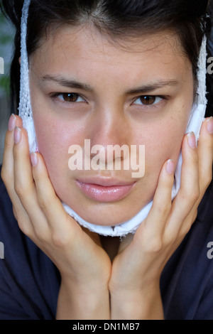 Adolescent remet de l'enlèvement de dents de sagesse à l'aide d'un pack de froid Banque D'Images