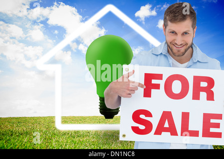 Composite image of model holding a for sale sign Banque D'Images