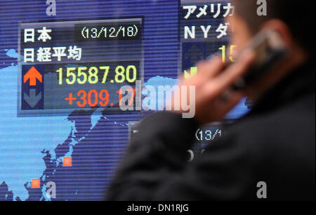 Tokyo, Japon. Dec 18, 2013. Un homme passe devant un panneau électronique indiquant l'indice Nikkei à Tokyo, Japon, 18 décembre 2013. La question de 225 Nikkei Stock Average fermé 309,17 points à 15 587,80. © Stringer/Xinhua/Alamy Live News Banque D'Images