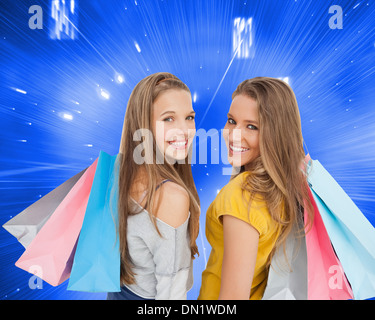 Image composite de deux jeunes femmes with shopping bags Banque D'Images