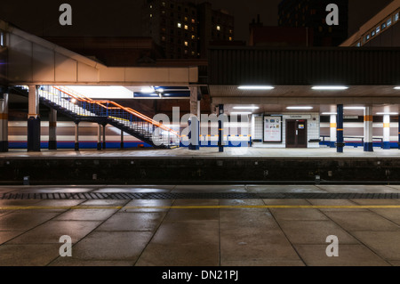 Longue exposition d'un service de trains de voyageurs East Midlands qui passe par la gare de Leicester la nuit. Banque D'Images