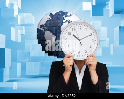 Composite image of businesswoman in suit holding a clock Banque D'Images