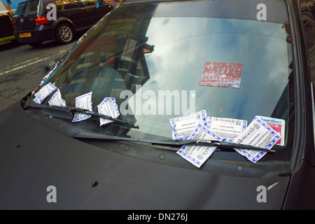 Voiture abandonnée avec beaucoup de billets sur son pare-brise. Banque D'Images