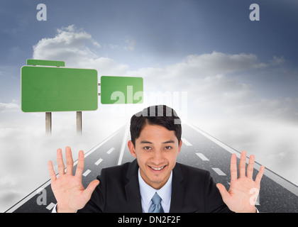 Composite image of businessman holding hands up Banque D'Images