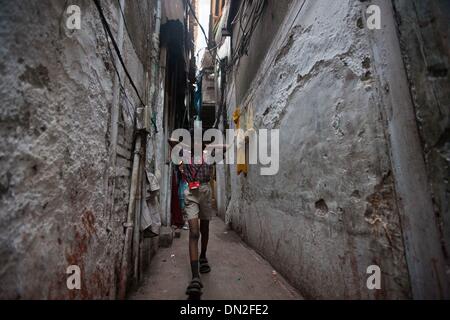 Mumbai, Inde. Dec 18, 2013. Un élève marche dans une ruelle dans le bidonville de Mumbai, Inde, 18 décembre 2013. De l'autre côté de l'Inde centre économique et financier, Mumbai, il se trouve un des plus grands bidonvilles du pays. Les résidents vivent dans des salles encombrées, minable, et le craps sont vus partout. Mais la vie à Mumbai, la bidonville n'est pas tout au sujet de la pauvreté et de pessimisme, certaines personnes ont commencé à ouvrir des magasins, d'envoyer leurs enfants à l'école et de faire des affaires. Banque D'Images