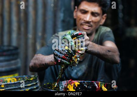 Mumbai, Inde. Dec 18, 2013. Un homme nettoie la peinture sur les godets dans le bidonville de Mumbai, Inde, 18 décembre 2013. De l'autre côté de l'Inde centre économique et financier, Mumbai, il se trouve un des plus grands bidonvilles du pays. Les résidents vivent dans des salles encombrées, minable, et le craps sont vus partout. Mais la vie à Mumbai, la bidonville n'est pas tout au sujet de la pauvreté et de pessimisme, certaines personnes ont commencé à ouvrir des magasins, d'envoyer leurs enfants à l'école et de faire des affaires. Banque D'Images