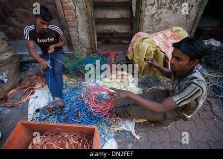 Mumbai, Inde. Dec 18, 2013. Les personnes sont considérées occupé à travailler dans une ruelle dans le bidonville de Mumbai, Inde, 18 décembre 2013. De l'autre côté de l'Inde centre économique et financier, Mumbai, il se trouve un des plus grands bidonvilles du pays. Les résidents vivent dans des salles encombrées, minable, et le craps sont vus partout. Mais la vie à Mumbai, la bidonville n'est pas tout au sujet de la pauvreté et de pessimisme, certaines personnes ont commencé à ouvrir des magasins, d'envoyer leurs enfants à l'école et de faire des affaires. Banque D'Images