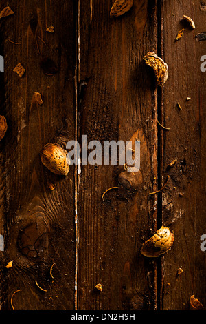 Coquilles d'Amandes éparpillées sur bois Banque D'Images
