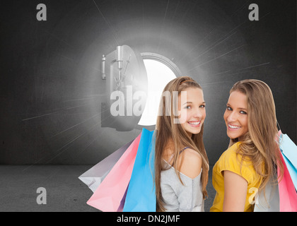 Image composite de deux jeunes femmes with shopping bags Banque D'Images