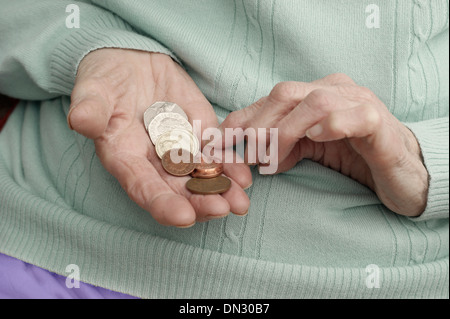 Vieille Femme tenant un mélange de pièces (en passant par de l'argent à l'ère d'austérité) Banque D'Images