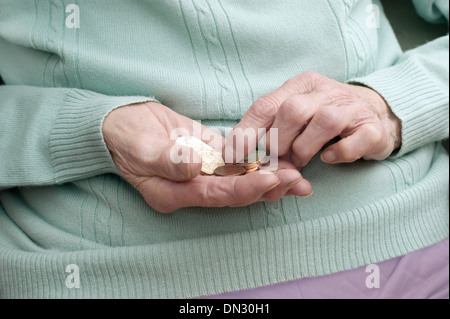 Vieille Femme tenant un mélange de pièces (en passant par de l'argent à l'ère d'austérité) Banque D'Images