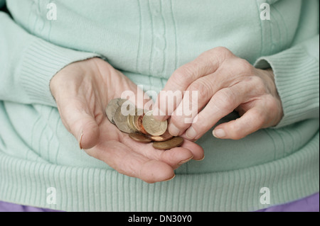 Vieille Femme tenant un mélange de pièces (en passant par de l'argent à l'ère d'austérité) Banque D'Images