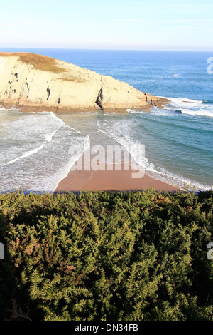 Île reliée par une langue de sable de la côte, avec des vagues sur les deux côtés Banque D'Images