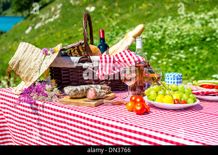 Goûté à pique-niquer sur l'herbe près d'un lac Banque D'Images