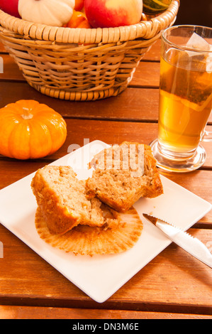 Muffin coupé en deux sur une plaque avec une tasse de thé et des citrouilles Banque D'Images