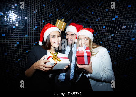 Portrait de joyeux collègues de Santa caps having fun in nightclub Banque D'Images