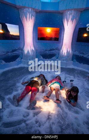 Les enfants faisant semblant de faire des anges dans la neige dans la neige artificielle du palais de glace affichage de Noël au Beverly Center à Los Angeles, CA Banque D'Images