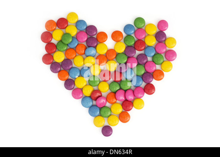 Coeur en smarties colorés sur fond blanc. Banque D'Images