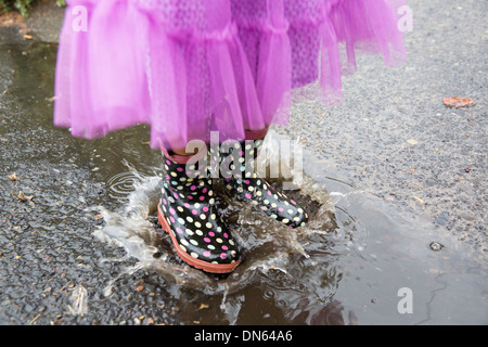 Mixed Race girl playing in puddle Banque D'Images