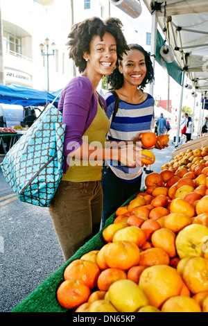 Shopping femmes ensemble au stand de fruits Banque D'Images