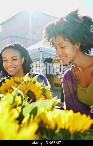 Shopping femmes ensemble au stand de fleurs Banque D'Images