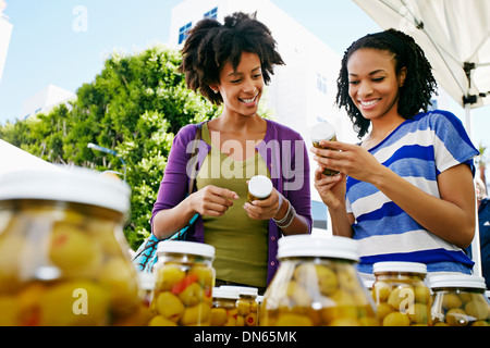 Women smiling together at outdoor market Banque D'Images