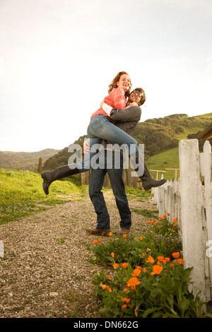 Couple hugging in rural landscape Banque D'Images