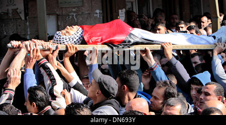 Qalqilya. Dec 19, 2013. Les Palestiniens portent le corps de Saleh Yassine lors de ses funérailles dans la ville cisjordanienne de Qalqilya, le 19 décembre 2013. Les forces israéliennes ont abattu deux jeunes Palestiniens au cours d'affrontements en Cisjordanie, selon des sources médicales et de sécurité. Credit : Mahmoud Shanti/Xinhua/Alamy Live News Banque D'Images