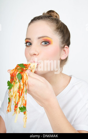 Woman eating spaghetti en le tenant dans votre main Banque D'Images