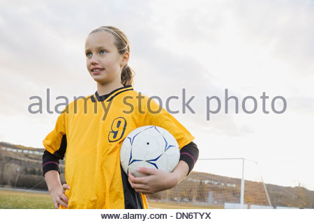 Portrait de joueur de foot avec ballon sur terrain
