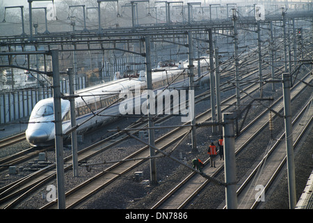 Vérifier les marcheurs de la voie voie tandis qu'un train à grande vitesse va passer en gare sud de Beijing, à Beijing, en Chine. 15-Déc-2013 Banque D'Images