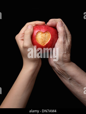 Female hands holding apple, isolé sur fond noir Banque D'Images