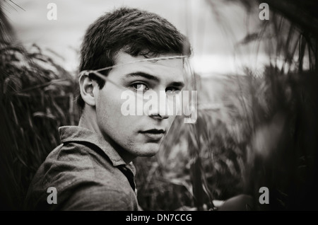 Young man standing in cornfield, portrait Banque D'Images