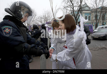 Kiev, Ukraine. Dec 19, 2013. Deux personnes habillées comme des anges de l'opposition donnent des cadeaux aux agents de police qui sont de garde dans le quartier du gouvernement à Kiev, Ukraine, le 19 décembre 2013. Les manifestations sont dirigées contre la politique du président ukrainien et d'une closening de ses liens avec l'UE. Photo : Jan A. Nicolas/dpa/Alamy Live News Banque D'Images