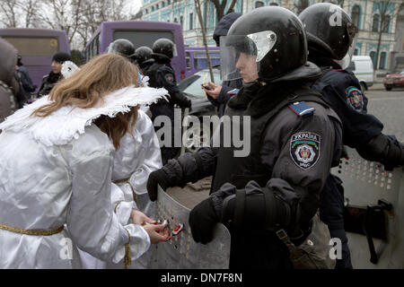 Kiev, Ukraine. Dec 19, 2013. Deux personnes habillées comme des anges de l'opposition donnent des cadeaux aux agents de police qui sont de garde dans le quartier du gouvernement à Kiev, Ukraine, le 19 décembre 2013. Les manifestations sont dirigées contre la politique du président ukrainien et d'une closening de ses liens avec l'UE. Photo : Jan A. Nicolas/dpa/Alamy Live News Banque D'Images