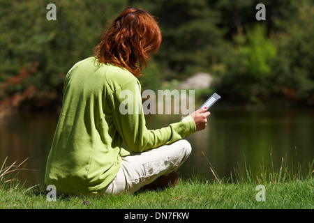 Femme lisant un livre numérique Banque D'Images