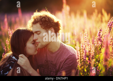 Jeune couple dans l'amour embrassant sur un pré