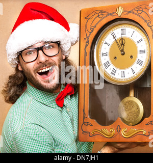 Photo de étourdis Santa avec réveil montrant cinq minutes avant minuit Banque D'Images