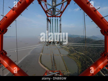 Zhoushan, Chine, Province de Zhejiang. 18Th Oct, 2013. Les électriciens travaillent sur les lignes de transmission de plus de 190 mètres au-dessus du sol à Hefei, Chine de l'est la province du Zhejiang, le 19 décembre 2013. La croix de 500 kilovolts-sea power transmission projet devrait mettre en service en janvier 2014. Les 36,5 kilomètres de long projet, dont 8,39 kilomètres de mer, a été la plus longue de ce type en Chine jusqu'à présent. © Xu Yu/Xinhua/Alamy Live News Banque D'Images