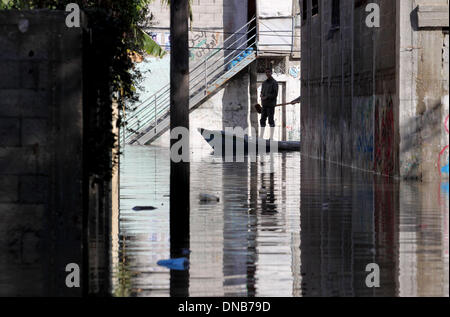 La ville de Gaza, bande de Gaza, territoire palestinien. Dec 21, 2013. Les secouristes palestiniens aider les résidents à se déplacer sur un bateau dans la ville de Gaza, 21 décembre 2013. Les sauveteurs ont évacué des milliers de résidents de la bande de Gaza dans des maisons inondées par de fortes pluies, à l'aide de bateaux de pêche et de matériel de construction lourde à arracher certains de ceux qui sont prisonniers depuis les étages supérieurs Crédit : Mohammed Asad APA/Images/ZUMAPRESS.com/Alamy Live News Banque D'Images