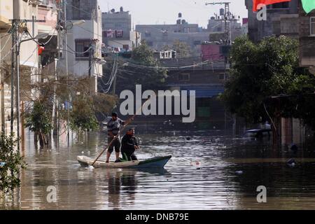 La ville de Gaza, bande de Gaza, territoire palestinien. Dec 21, 2013. Les secouristes palestiniens aider les résidents à se déplacer sur un bateau dans la ville de Gaza, 21 décembre 2013. Les sauveteurs ont évacué des milliers de résidents de la bande de Gaza dans des maisons inondées par de fortes pluies, à l'aide de bateaux de pêche et de matériel de construction lourde à arracher certains de ceux qui sont prisonniers depuis les étages supérieurs Crédit : Mohammed Asad APA/Images/ZUMAPRESS.com/Alamy Live News Banque D'Images