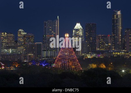 Le sentier des lumières et l'arbre de noël parc Zilker sont éclairés à l'avant du centre-ville d'Austin skyline pendant les vacances. Banque D'Images
