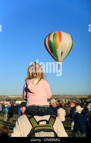 Petite fille sur les épaules de Papa regarder hot air balloon, Albuquerque International Balloon Fiesta, Albuquerque, Nouveau Mexique USA Banque D'Images